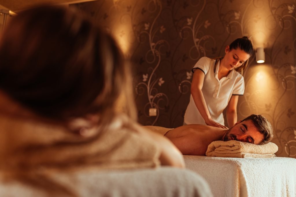 Female masseur massaging male at a spa